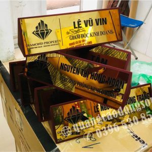 Biển chức danh tam giác 2 mặt được sản xuất theo yêu cầu với chất liệu đồng, inox hoặc mica cao cấp, hiển thị thông tin ở cả hai mặt, phù hợp đặt trên bàn làm việc, bàn họp, quầy lễ tân, phòng giao dịch và phòng tiếp dân. Thiết kế sang trọng, gia công sắc nét, bền đẹp và dễ quan sát từ nhiều hướng.